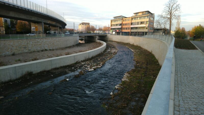 Fluß, links und rechts Hochwasserschutzmauern