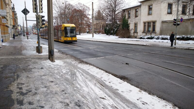 Eine gelbe Straßenbahn der Linie 6 (erste neue Generation) auf der Kesselsdorfer Straße / Rudolf-Renner-Straße am 14.12.2022
