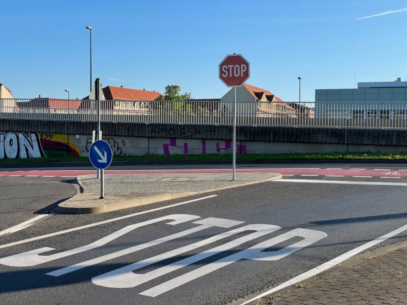 Große Schrift "STOP" und das linke Schild. Gut zu sehen ist hier der querende Fahrradweg.