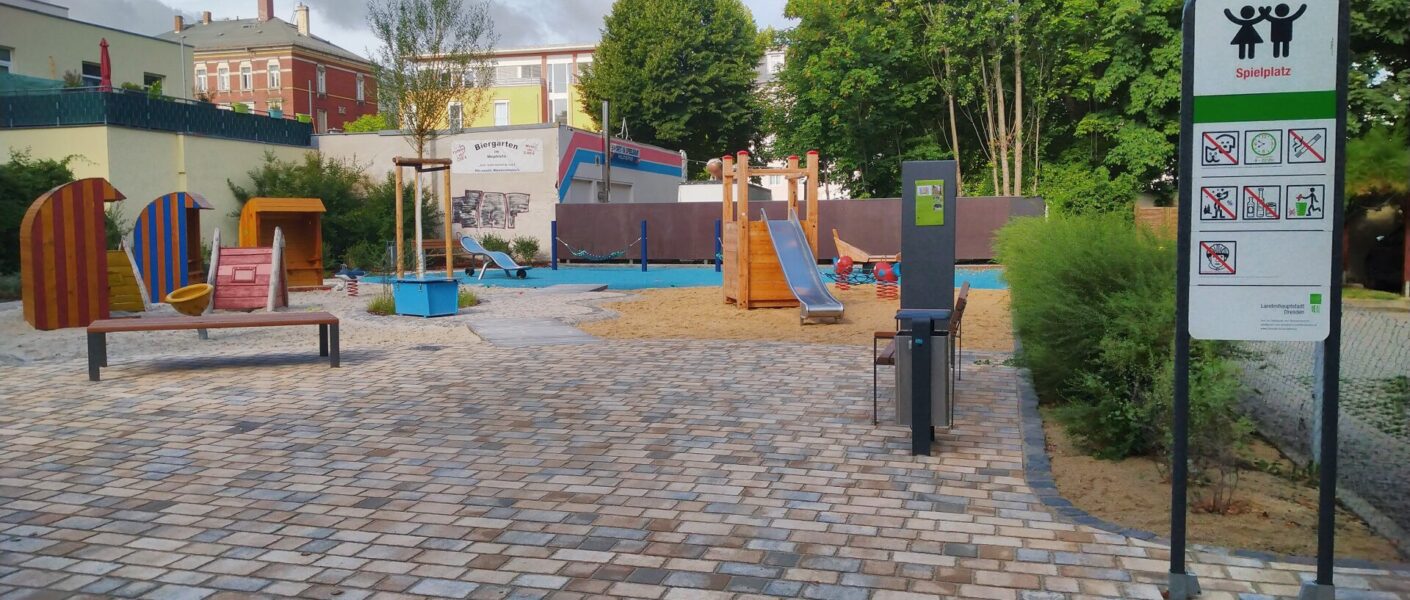 Der neue Strand-spielplatz. Rechts das Spielplatzschild. Im Hintergrund die neuen Strandkörbe, die "alte" Wippe und der "alte" Sand.