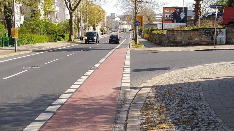 Zwei Spuren der Tharandter Straße mit zwei Radfahrstreifen. Von rechts mündet die Anton-Weck-Straße ein. Es gibt keine Fußgängerquerung.