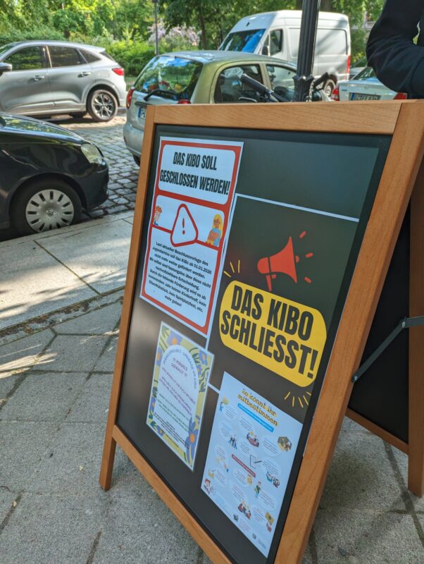 Ein Aufsteller mit Plakaten. U.a. "DAS KIBO SCHLIESST!"