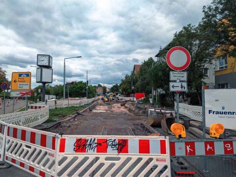 Straße komplett aufgerissen und abgesperrt. Vorner kann man noch Reste von Gleisen erkenen.